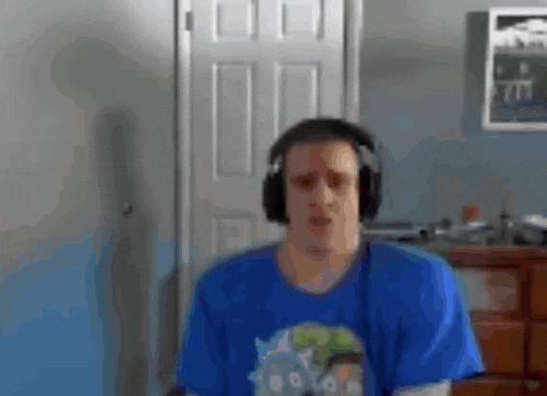 a man wearing headphones and a blue shirt is standing in front of a door .