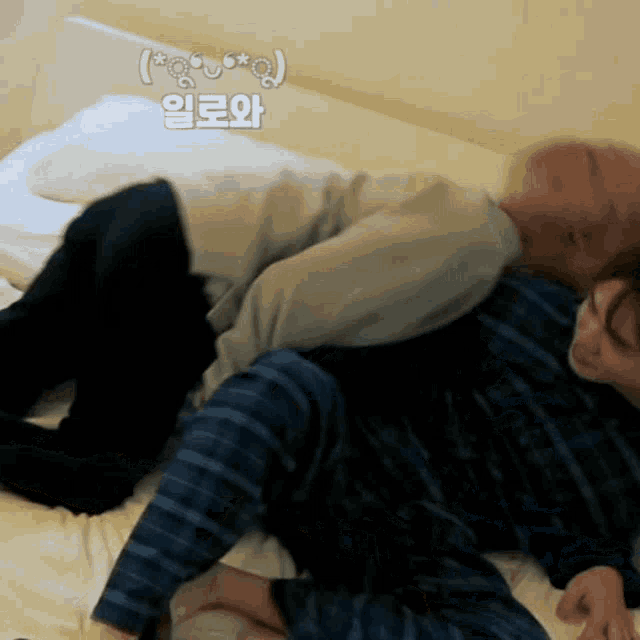 a couple laying on a bed with a foreign language written on the wall
