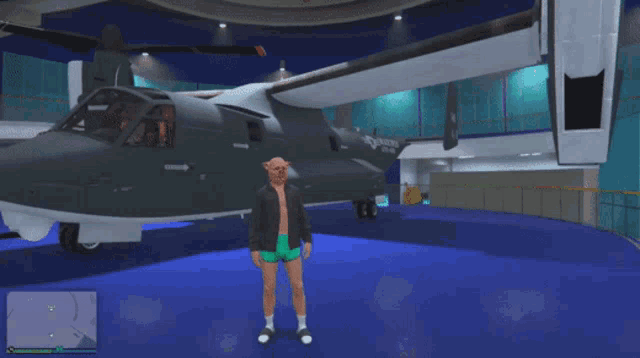 a man in shorts stands in front of a military plane that says us navy