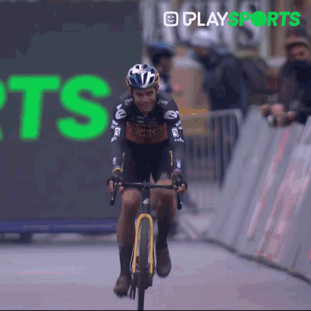 a man riding a bike in front of a play sports sign