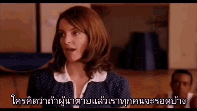 a woman in a polka dot dress is talking to a man in a room in a foreign language .