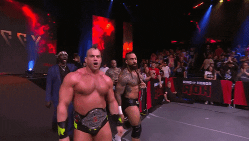 two wrestlers on a stage with the words who better than the embassy huh on the bottom
