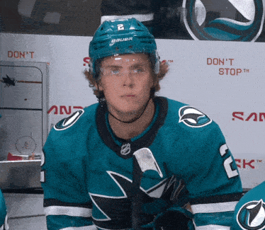 a hockey player wearing a bauer helmet looks at the camera