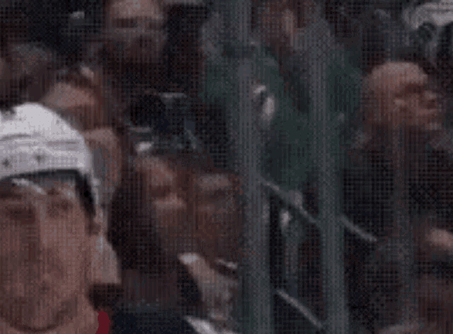 a woman is sitting in the stands watching a hockey game .