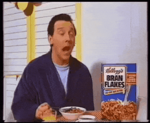 a man in a robe is eating kellogg 's bran flakes cereal