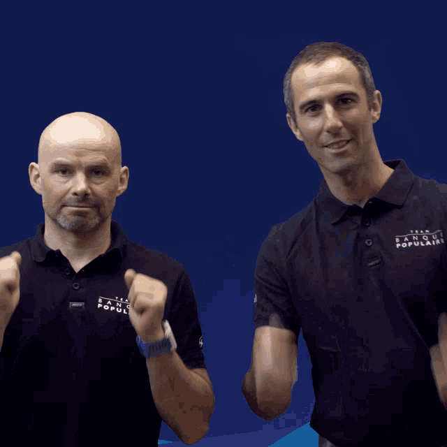 two men giving a thumbs up with one wearing a shirt that says ' altitude '