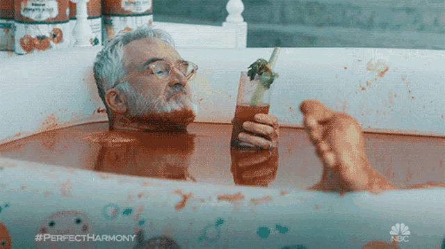 a man in a bathtub holding a bloody mary with the hashtag #perfectharmony