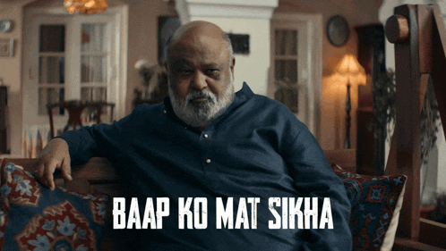 a man with a beard sits on a couch with baap ko mat sikha written on the bottom
