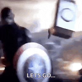 a man in a captain america costume is standing next to a shield and saying `` lets go '' .