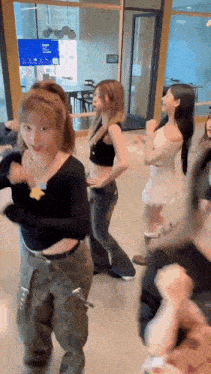 a group of girls are dancing in a room .
