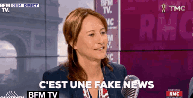 a woman is talking into a microphone with the words c'est une fake news behind her