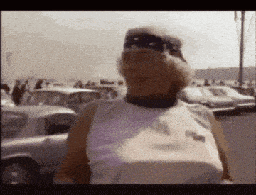 a woman wearing sunglasses and a bandana is walking down the street