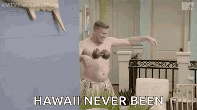 a shirtless man in a hawaiian outfit is holding a coconut in his hands and says `` hawaii never been '' .