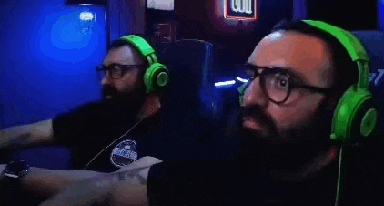 a man with a beard and glasses is wearing green headphones and playing a video game .