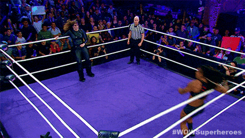 a wrestling ring with a referee and #wow superheroes written on the bottom