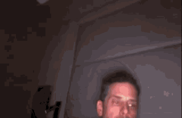 a man is blowing out a candle in a dark room