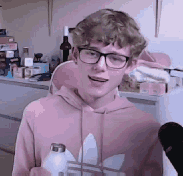 a boy wearing glasses and a pink adidas sweatshirt