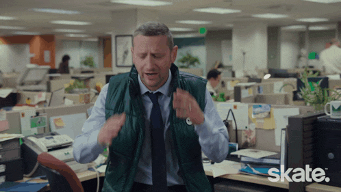 a man wearing a green vest and tie is in an office with skate written on the bottom