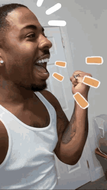 a man in a white tank top is laughing