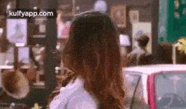 a woman is standing in front of a car in a store .