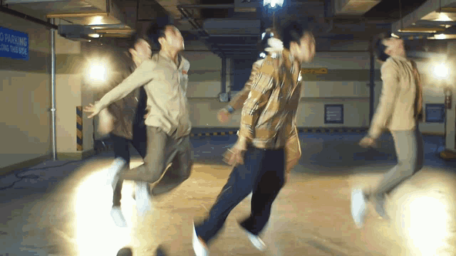 a group of men are jumping in the air in front of a sign that says no parking