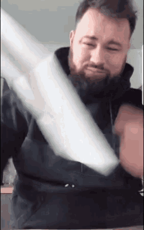 a man with a beard is holding up a piece of paper