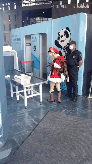 a man in a mask stands next to a girl in a santa outfit
