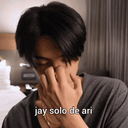 a man covering his face with his hand with the words jay solo de ari written below