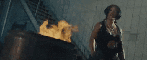 a man is standing in front of a fire in a building .