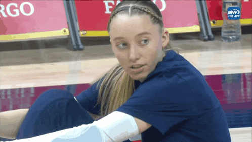 a girl with a bandage on her arm sits on the floor