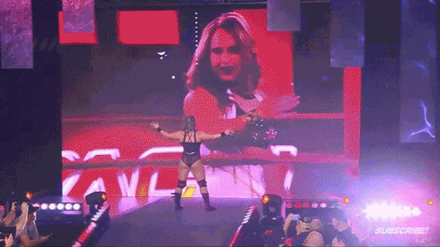 a wrestling match is being shown on a large screen with the word subscribe on it