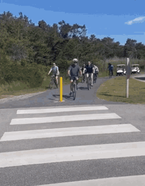 a group of people are riding bicycles on a path