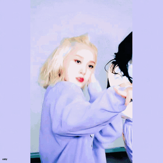 a woman in a purple sweater with a cupcake on it