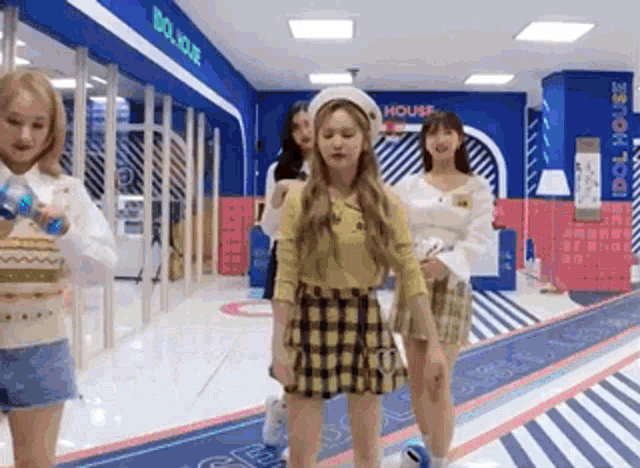 a group of girls are standing in a room with a striped floor .