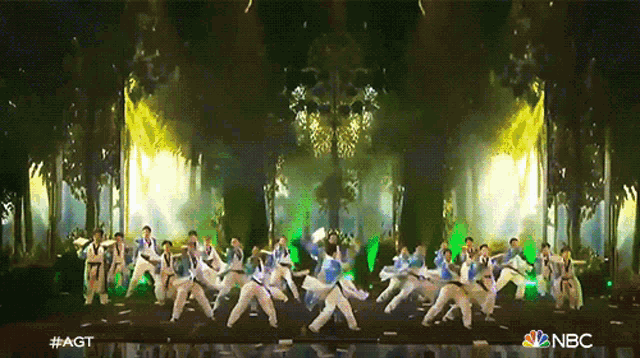 a group of people are performing on a stage with a nbc logo in the corner
