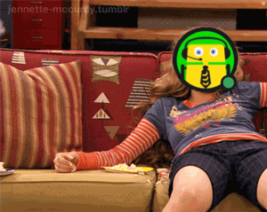 a girl is sitting on a couch with a picture of a cartoon character on her face
