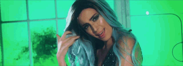 a woman with blue hair is smiling and looking at the camera