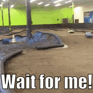 a rc car racing on a track with the words wait for me