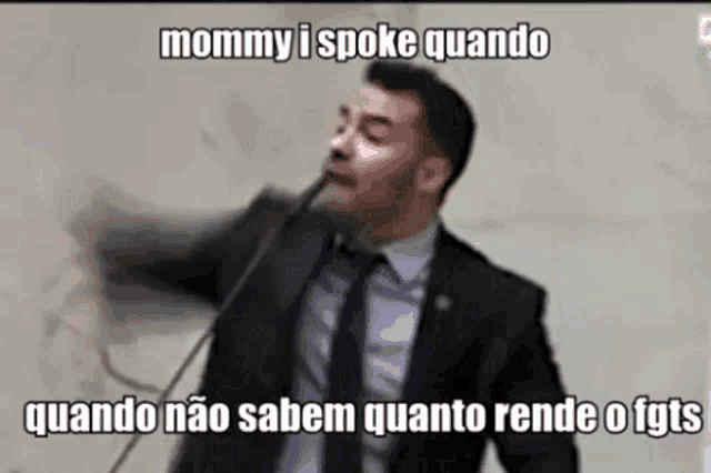 a man in a suit and tie is speaking into a microphone with the words mommy i spoke quando
