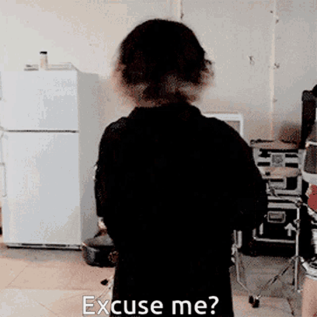 a person standing in front of a refrigerator with the words " excuse me " written on the floor