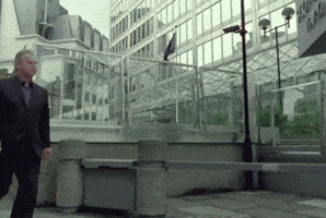 a man in a suit is walking in front of a building that has the word cisco on it