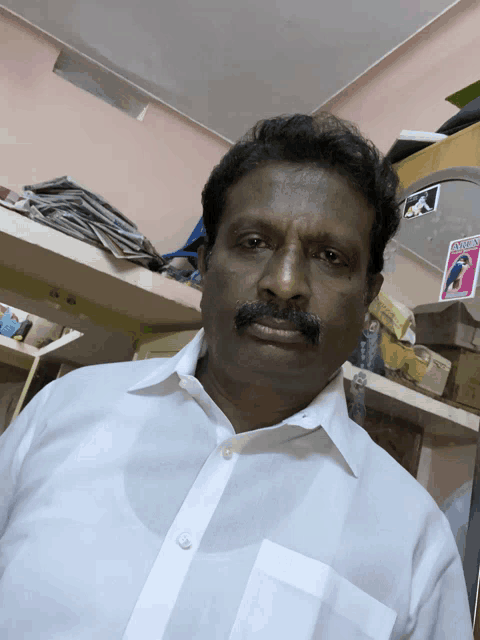 a man in a white shirt is standing in front of a shelf with a sticker on it that says ' a '