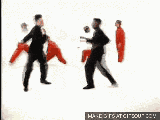 a group of men are dancing in a white room with a white background .