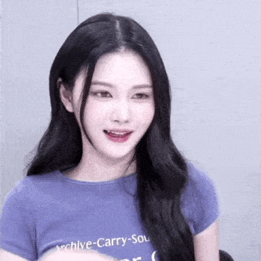a young woman with long black hair is wearing a purple t-shirt with the word archive on it .
