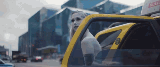 a woman is getting out of a taxi with a bull sign on top