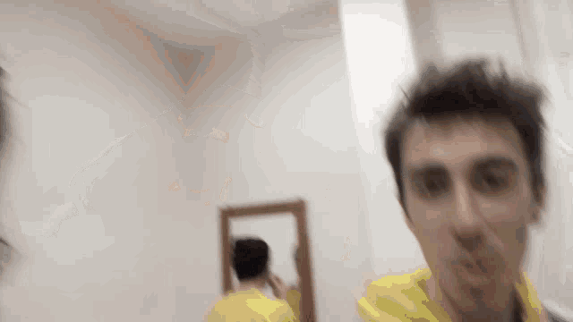 a blurry picture of a man looking at himself in the mirror