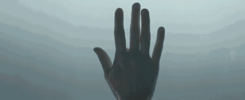 a close up of a person 's hand reaching out towards the sky .