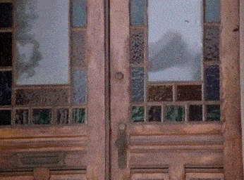 a wooden door with stained glass windows and a mailbox
