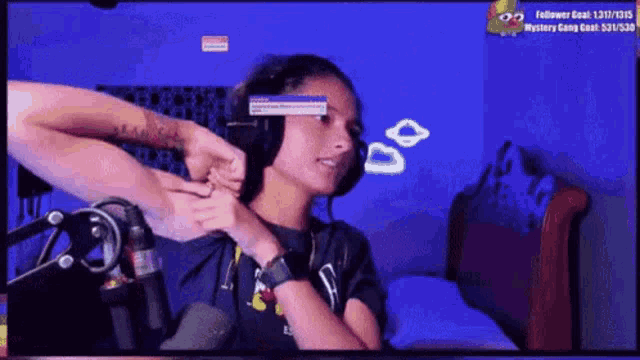 a woman wearing headphones is sitting in front of a microphone on a computer screen .