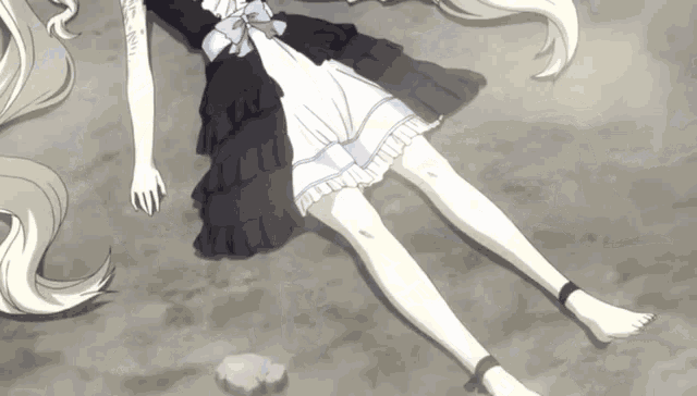 a girl in a black and white dress laying on the ground